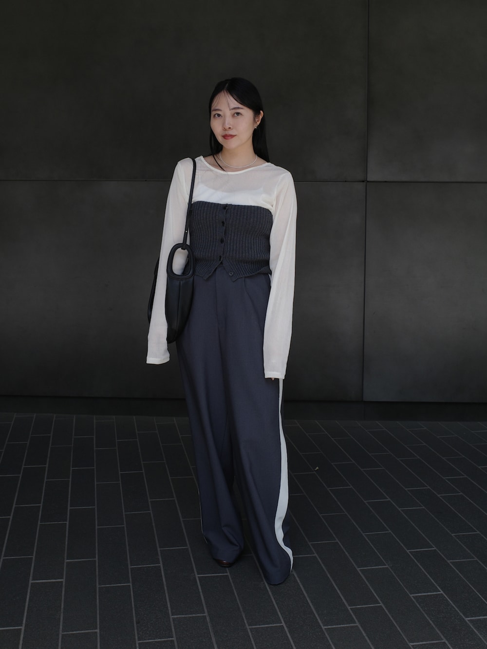 グレー系のその他パンツ、ホワイト系のTシャツ/カットソー、グレー系のニット/セーターを着用したレディースの秋コーディネートの2枚目の写真