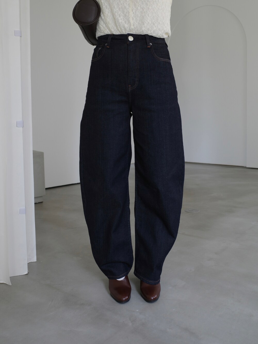 ブラウン系のシューズ、ホワイト系のTシャツ/カットソー、ブルー系のデニムパンツを着用したレディースの秋コーディネートの3枚目の写真