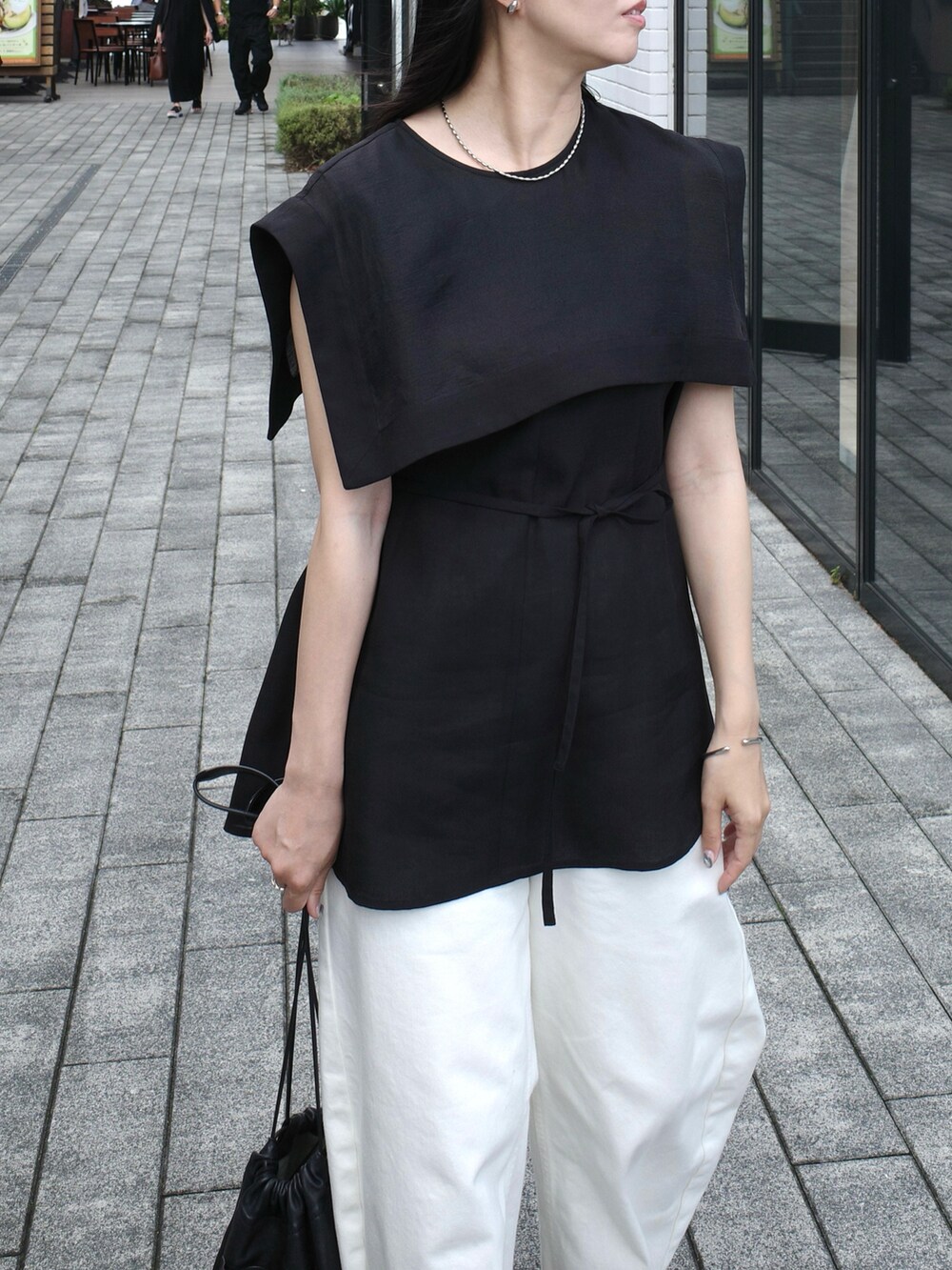 ホワイト系のショルダーバッグ、ホワイト系のデニムパンツ、ブラック系のシャツ/ブラウスを着用したレディースの秋コーディネートの4枚目の写真