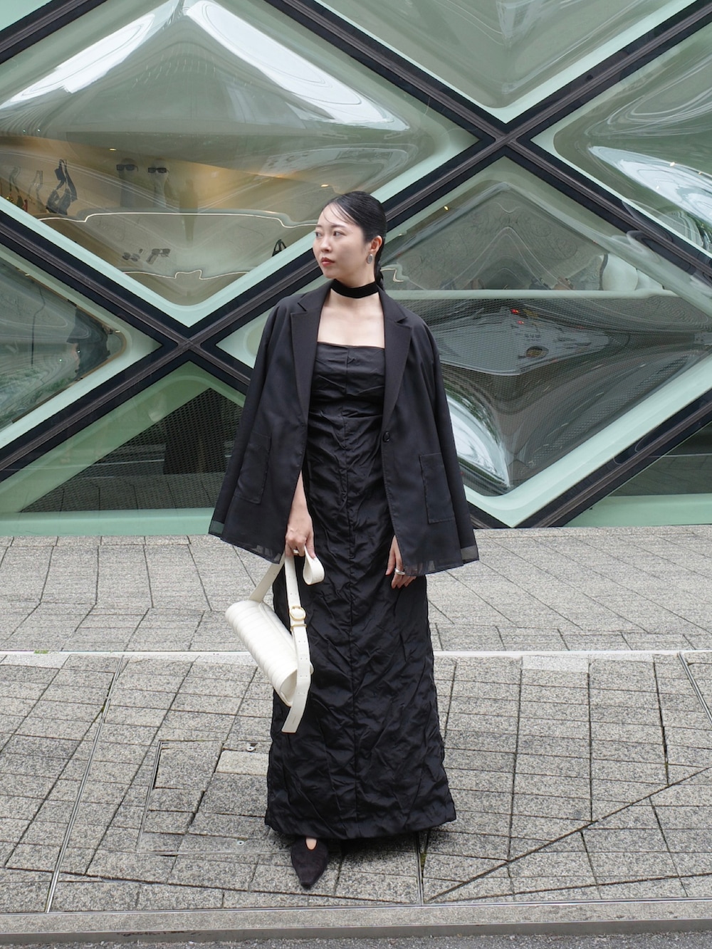 ブラック系のその他アウター、ブラック系のワンピース、ホワイト系のバッグを着用したレディースの秋コーディネートの4枚目の写真