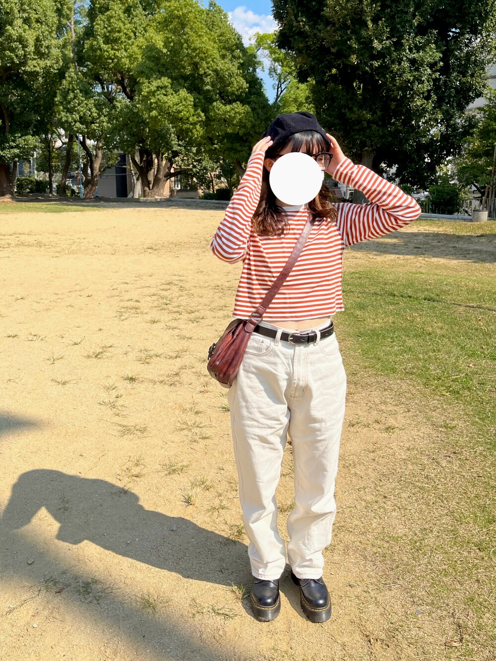 ベージュ系のデニムパンツ、ブラック系のブーツを着用したレディースの秋コーディネートの2枚目の写真