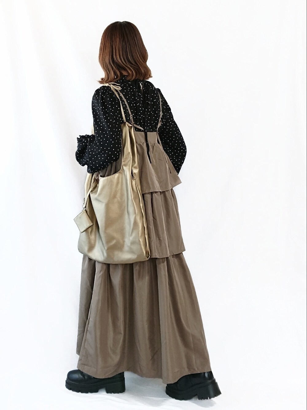 ベージュ系のワンピース、ブラック系のシャツ/ブラウス、ゴールド系のトートバッグを着用したレディースの冬コーディネートの2枚目の写真