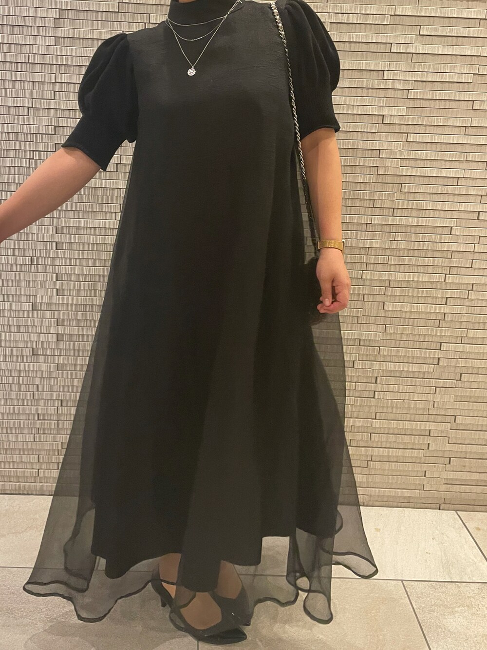 ブラック系のドレスを着用したレディースの秋コーディネートの2枚目の写真