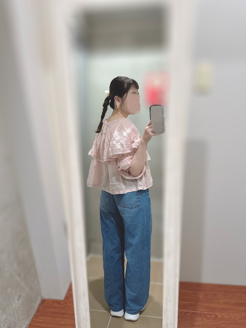 グレー系のスニーカー、ピンク系のカーディガン/ボレロ、ブルー系のデニムパンツを着用したレディースの秋コーディネートの2枚目の写真