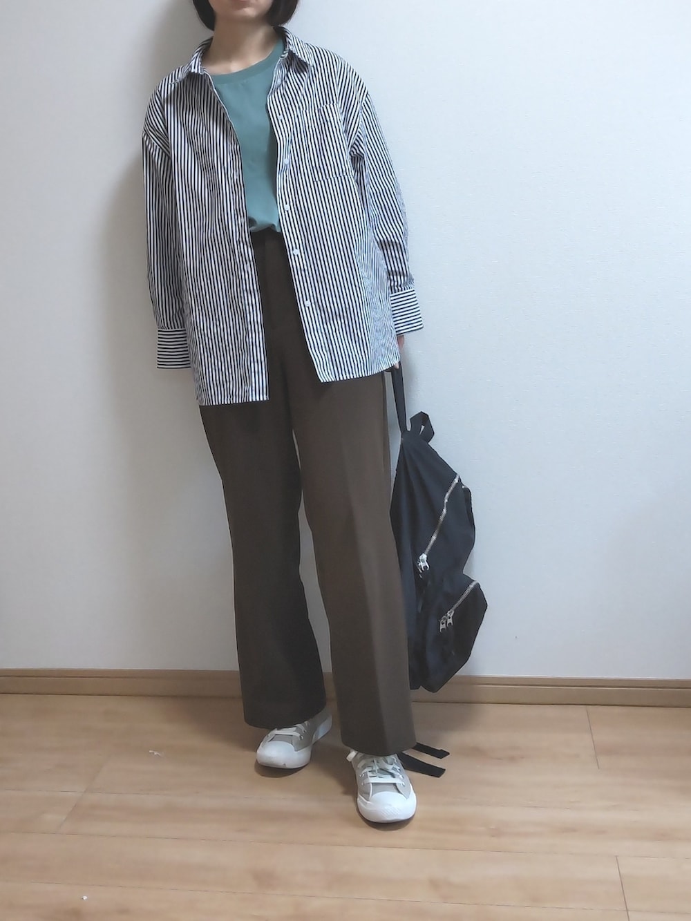 ブラック系のバックパック/リュック、ブラック系のシャツ/ブラウス、グリーン系のTシャツ/カットソーを着用したレディースの春コーディネートの2枚目の写真