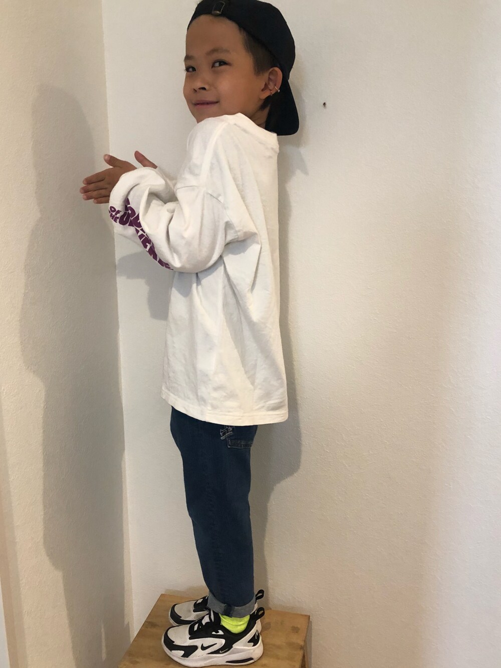 ブラック系のTシャツ/カットソー、ブルー系のパンツ、ブルー系のスニーカーを着用したキッズの春コーディネートの2枚目の写真