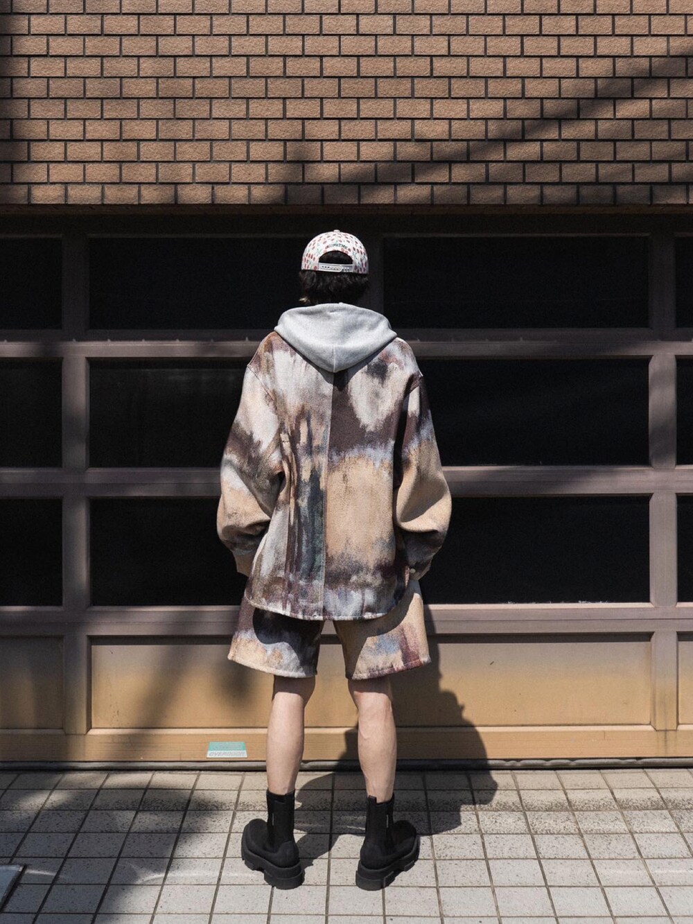 ブラウン系のジャケット/アウター、ブラウン系のパンツ、ブラック系のブーツを着用したメンズの春コーディネートの2枚目の写真