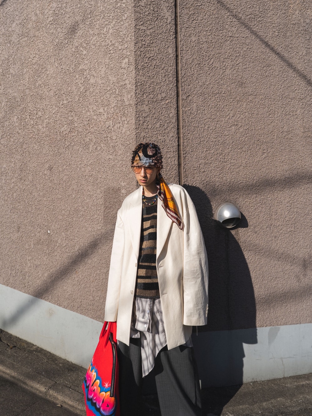 その他のトートバッグ、グレー系のスラックス、レッド系のハンドバッグを着用したメンズの春コーディネートの2枚目の写真