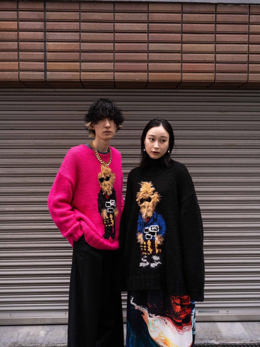 ピンク系のニット/セーター、ブラック系のニット/セーターを着用したメンズの春コーディネートの2枚目の写真