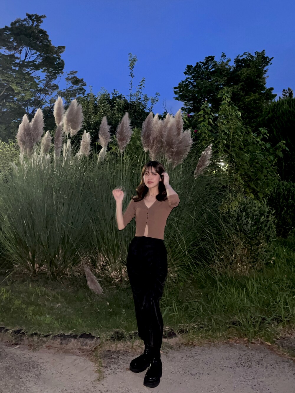 ブラウン系のカーディガン/ボレロ、ブラック系のスカート、ブラック系のブーツを着用したレディースの秋コーディネートの2枚目の写真