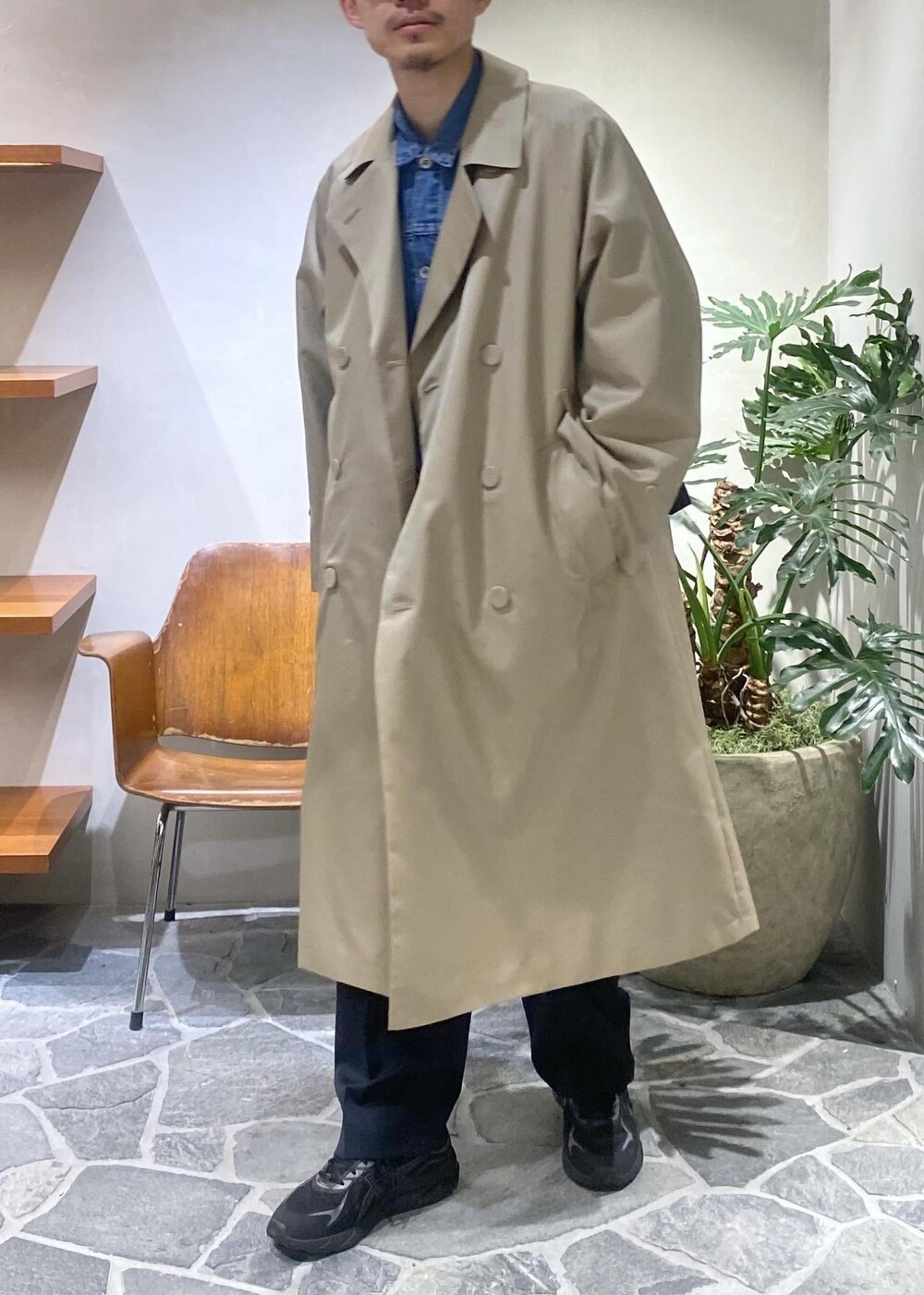 ベージュ系のトレンチコート、ブルー系のデニムジャケット、ブルー系のスラックスを着用したメンズの冬コーディネートの2枚目の写真