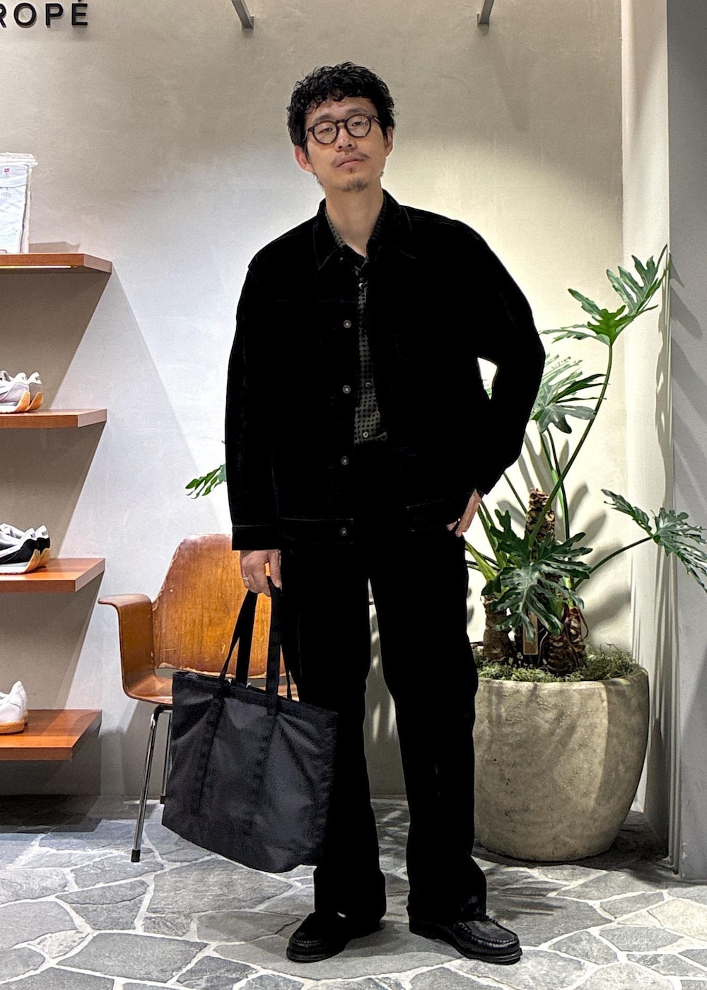 ブラック系のデニムジャケット、ブラック系のデニムパンツ、ブラック系のトートバッグを着用したメンズの秋コーディネートの2枚目の写真