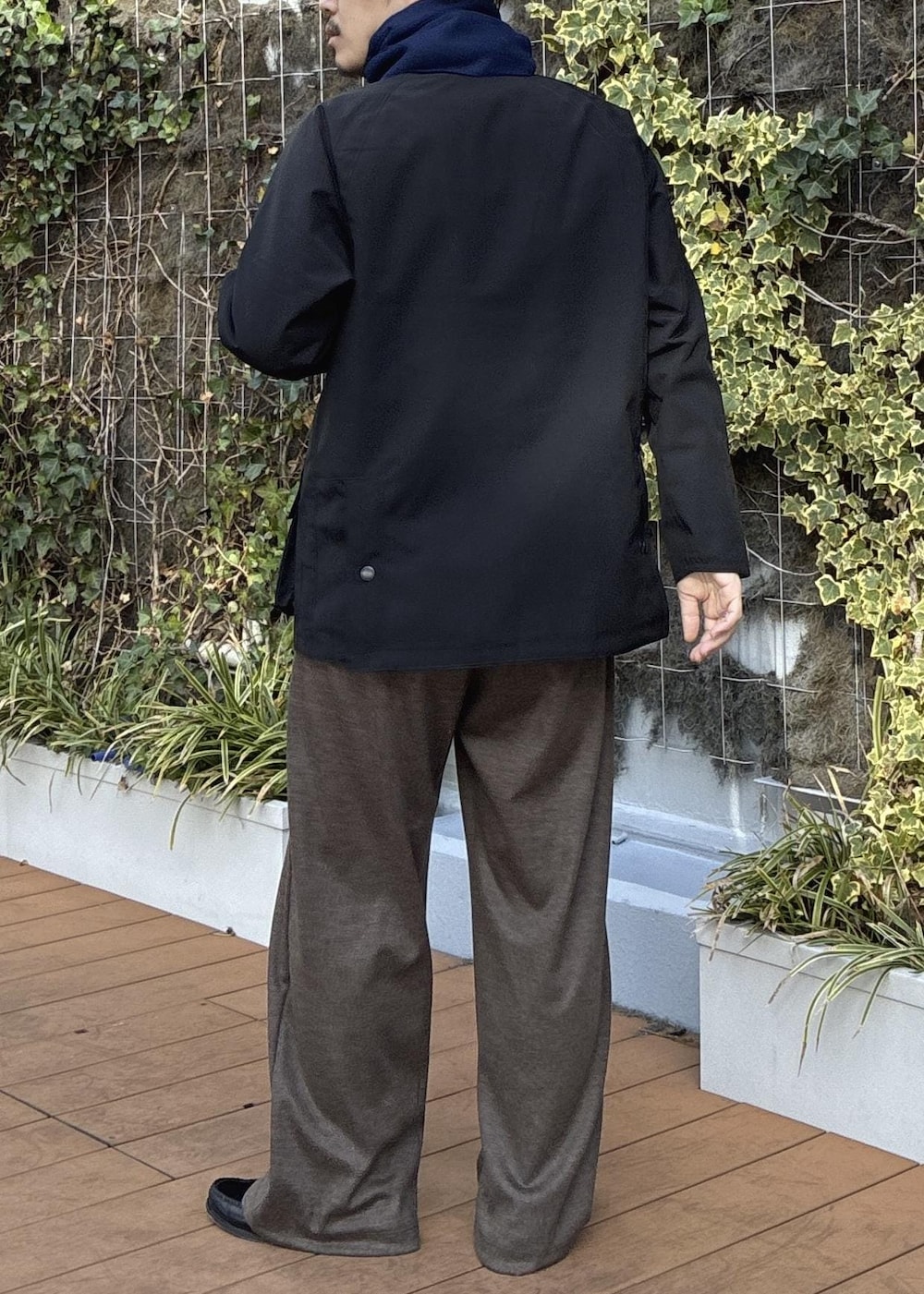 ピンク系のニット/セーター、ブラック系のその他アウター、ブルー系のマフラーを着用したメンズの冬コーディネートの8枚目の写真