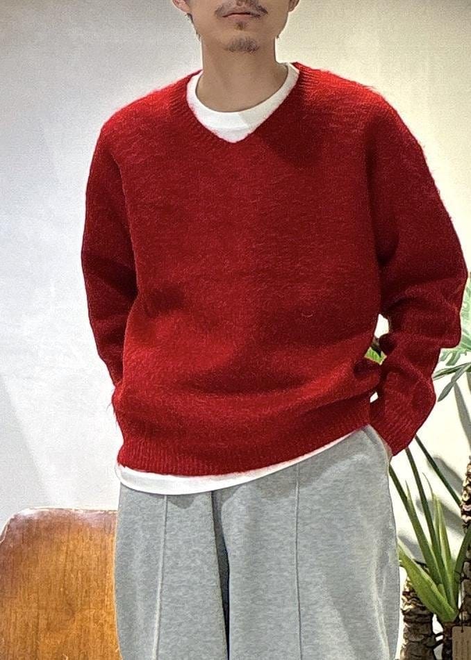 レッド系のニット/セーター、グレー系のその他パンツを着用したメンズの秋コーディネートの6枚目の写真