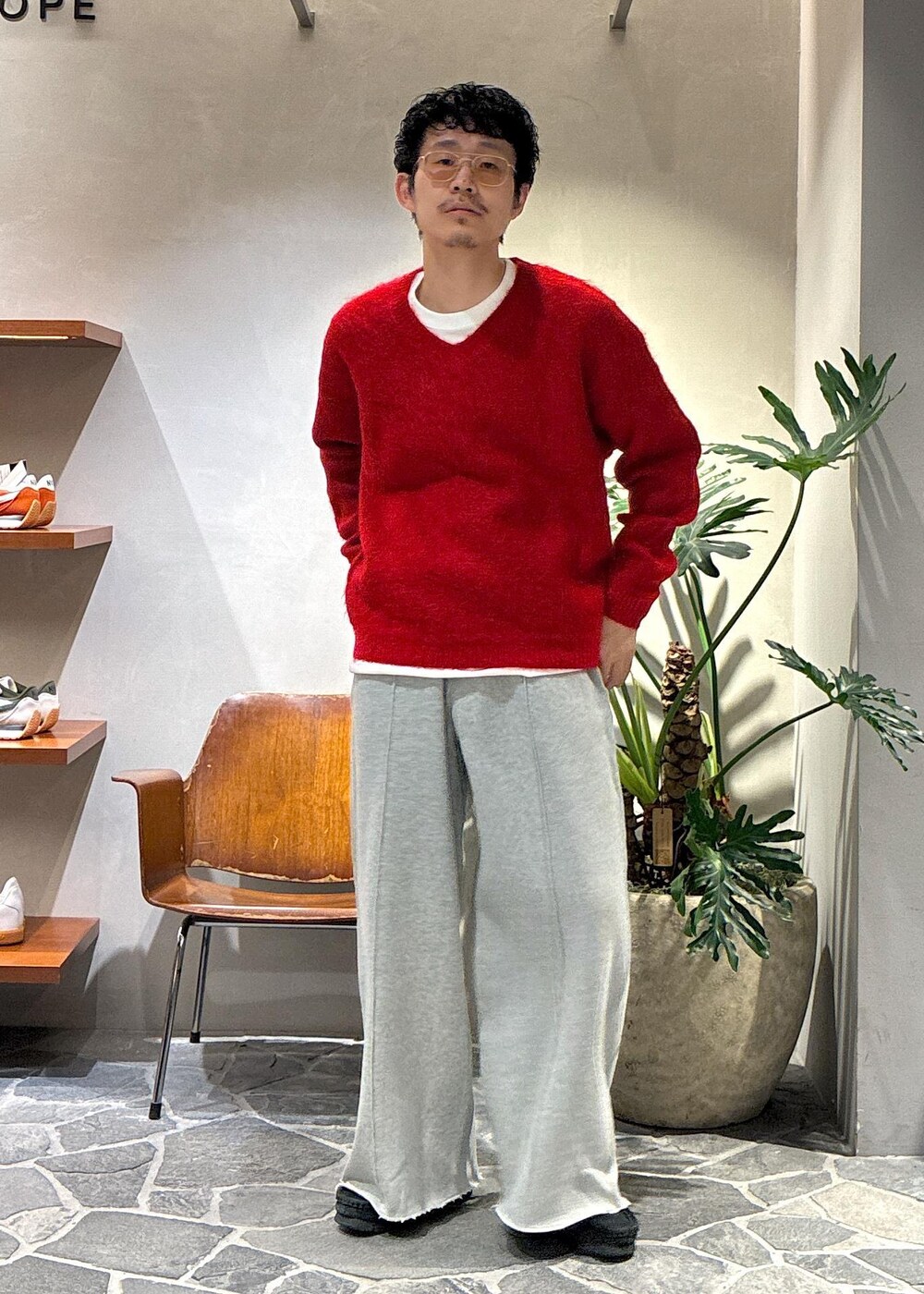 レッド系のニット/セーター、グレー系のその他パンツを着用したメンズの秋コーディネートの2枚目の写真