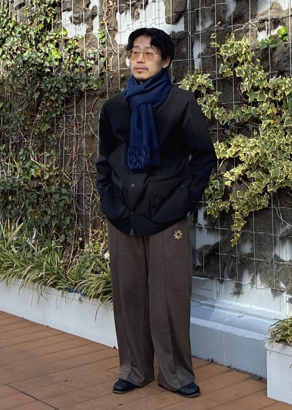 ピンク系のニット/セーター、ブラック系のその他アウター、ブルー系のマフラーを着用したメンズの冬コーディネートの2枚目の写真