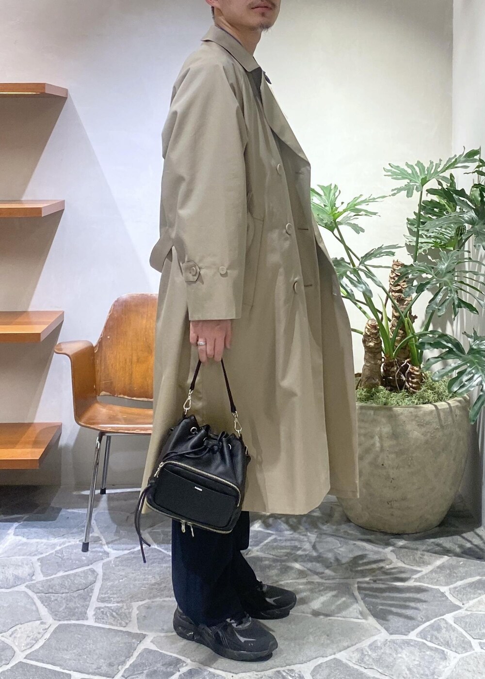 ベージュ系のトレンチコート、ブルー系のデニムジャケット、ブルー系のスラックスを着用したメンズの冬コーディネートの3枚目の写真
