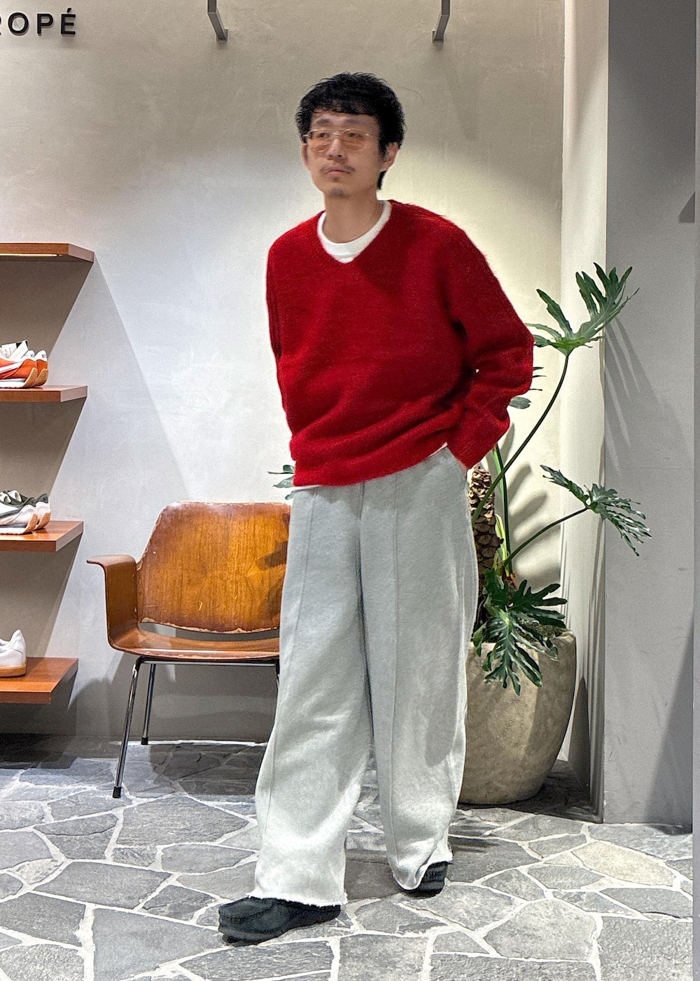 レッド系のニット/セーター、グレー系のその他パンツを着用したメンズの秋コーディネートの3枚目の写真