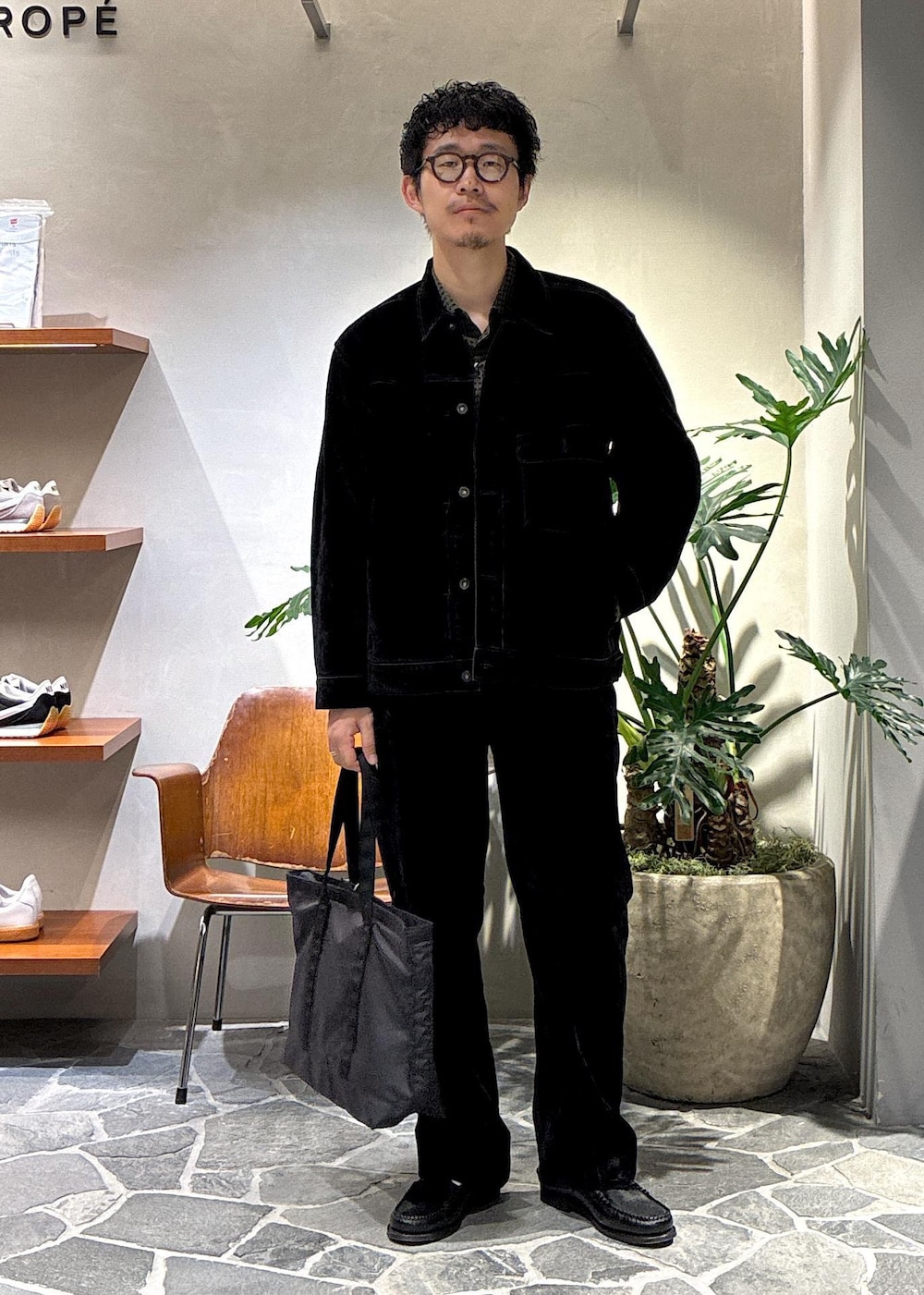 ブラック系のデニムジャケット、ブラック系のデニムパンツ、ブラック系のトートバッグを着用したメンズの秋コーディネートの3枚目の写真