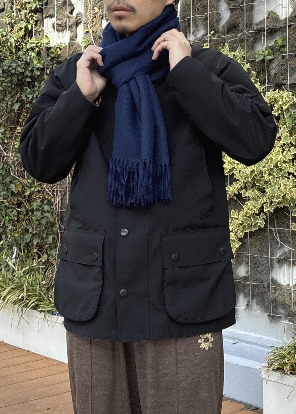 ピンク系のニット/セーター、ブラック系のその他アウター、ブルー系のマフラーを着用したメンズの冬コーディネートの9枚目の写真