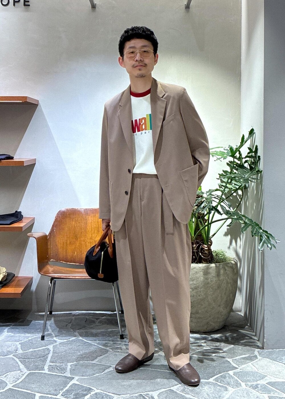 ブラウン系のスリッポン、イエロー系のスラックス、イエロー系のテーラードジャケットを着用したメンズの春コーディネートの2枚目の写真