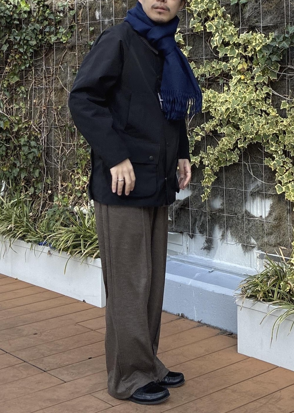 ピンク系のニット/セーター、ブラック系のその他アウター、ブルー系のマフラーを着用したメンズの冬コーディネートの7枚目の写真