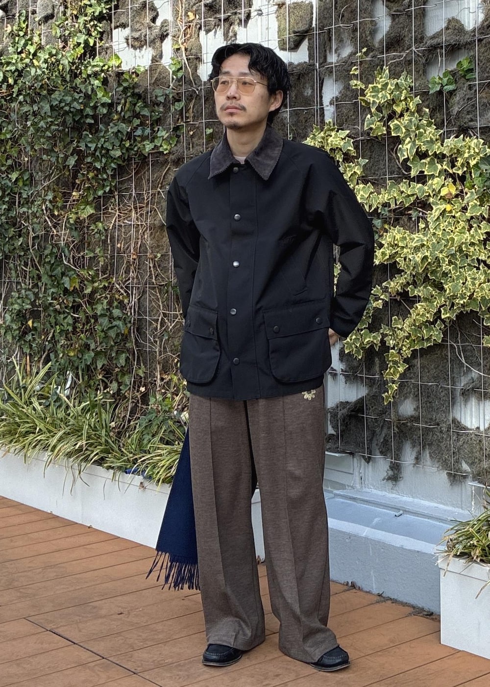 ピンク系のニット/セーター、ブラック系のその他アウター、ブルー系のマフラーを着用したメンズの冬コーディネートの3枚目の写真