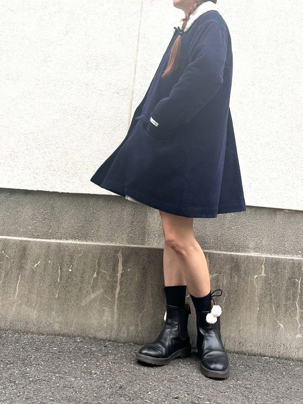 ブルー系のステンカラーコート、レッド系のスカート、ブラック系のソックス/靴下を着用したレディースの秋コーディネートの2枚目の写真