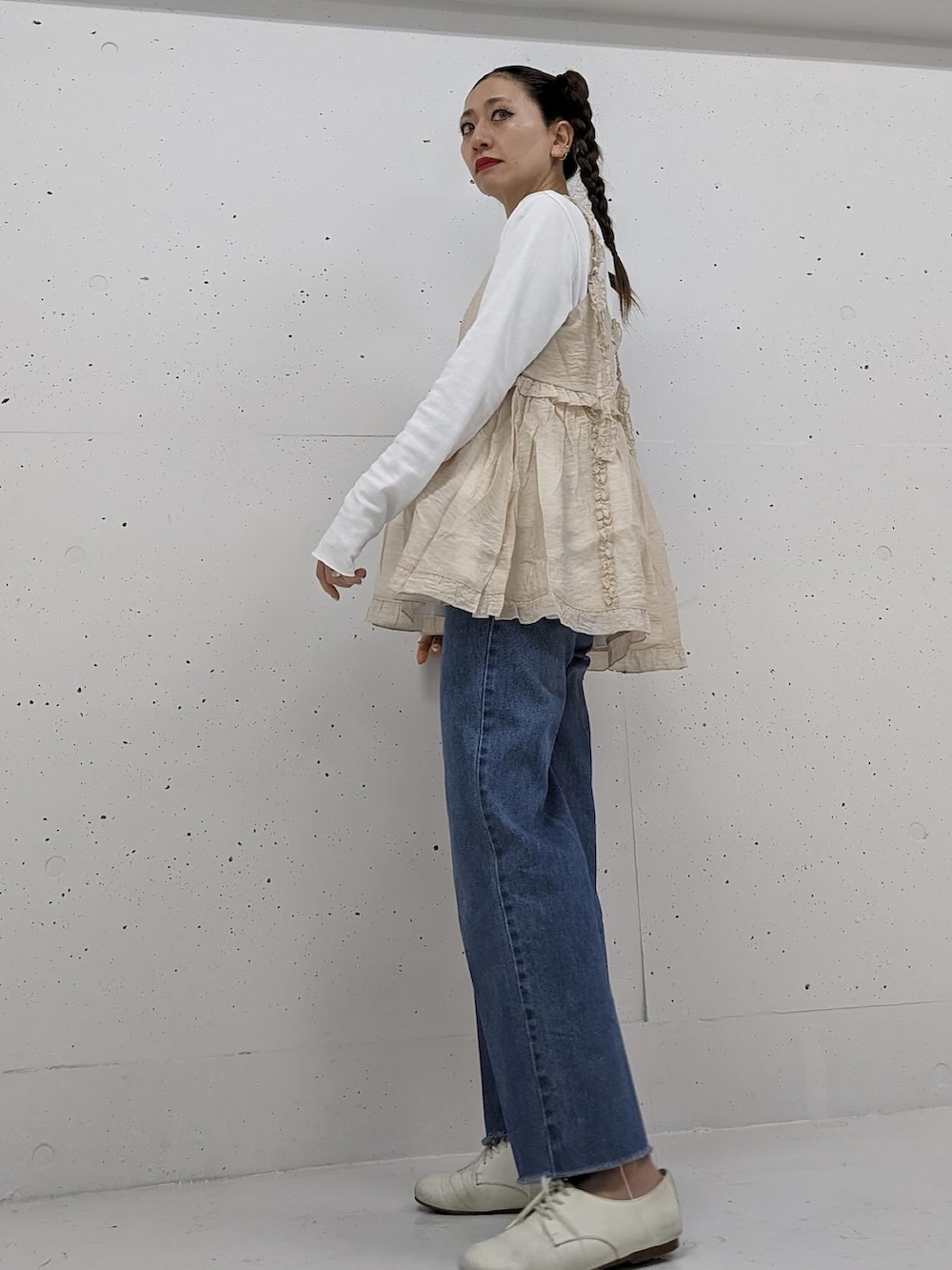 ベージュ系のキャミソール、ブルー系のデニムパンツを着用したレディースの春コーディネートの4枚目の写真