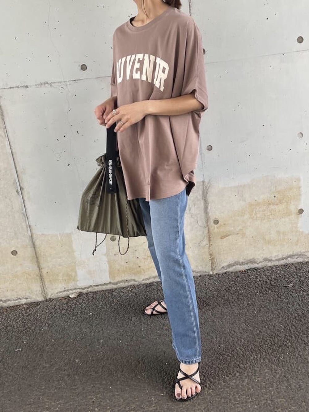 ブラウン系のTシャツ/カットソー、ブルー系のデニムパンツ、グリーン系のエコバッグ/サブバッグを着用したレディースの夏コーディネートの4枚目の写真