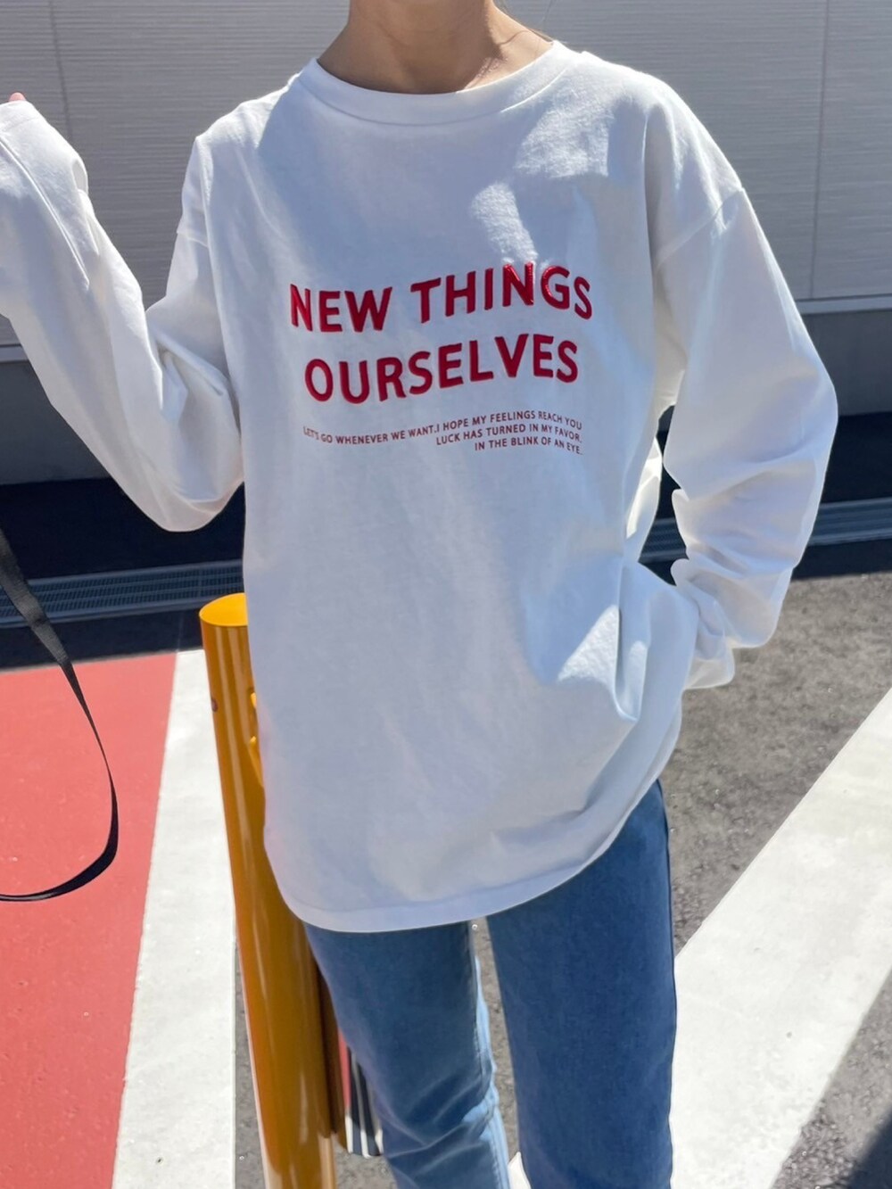 ホワイト系のTシャツ/カットソー、ブラック系のメッセンジャーバッグ、レッド系のスニーカーを着用したレディースの春コーディネートの5枚目の写真