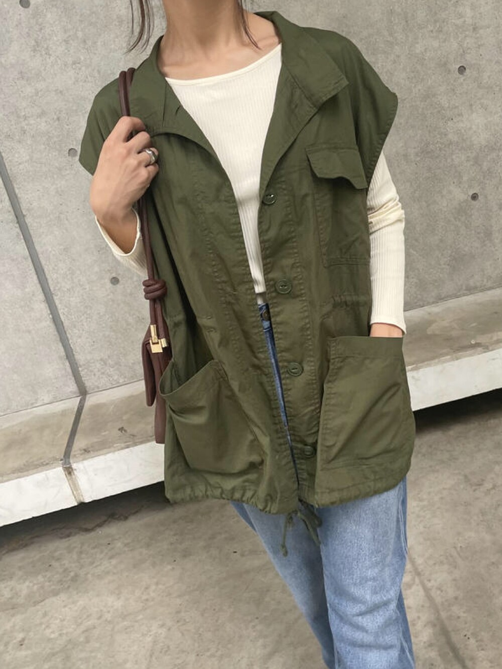 ホワイト系のTシャツ/カットソー、グリーン系のベスト、ブラウン系のショルダーバッグを着用したレディースの秋コーディネートの3枚目の写真