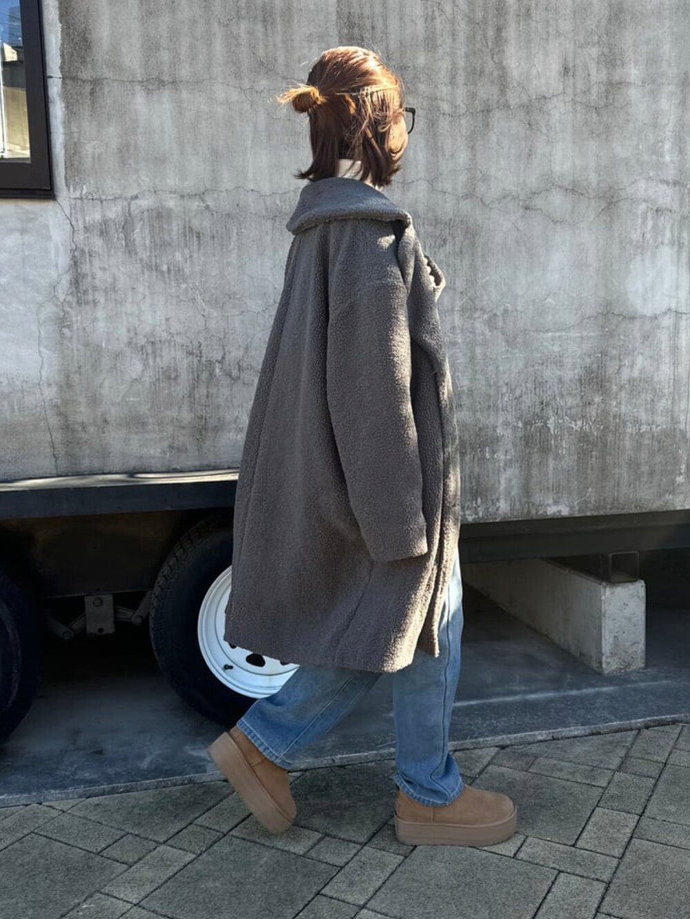 グレー系のその他アウター、ホワイト系のニット/セーター、ブルー系のデニムパンツを着用したレディースの冬コーディネートの3枚目の写真