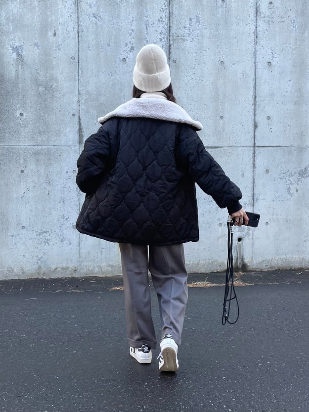 グレー系のスウェット、グレー系のパンツ、ホワイト系のスニーカーを着用したレディースの冬コーディネートの4枚目の写真