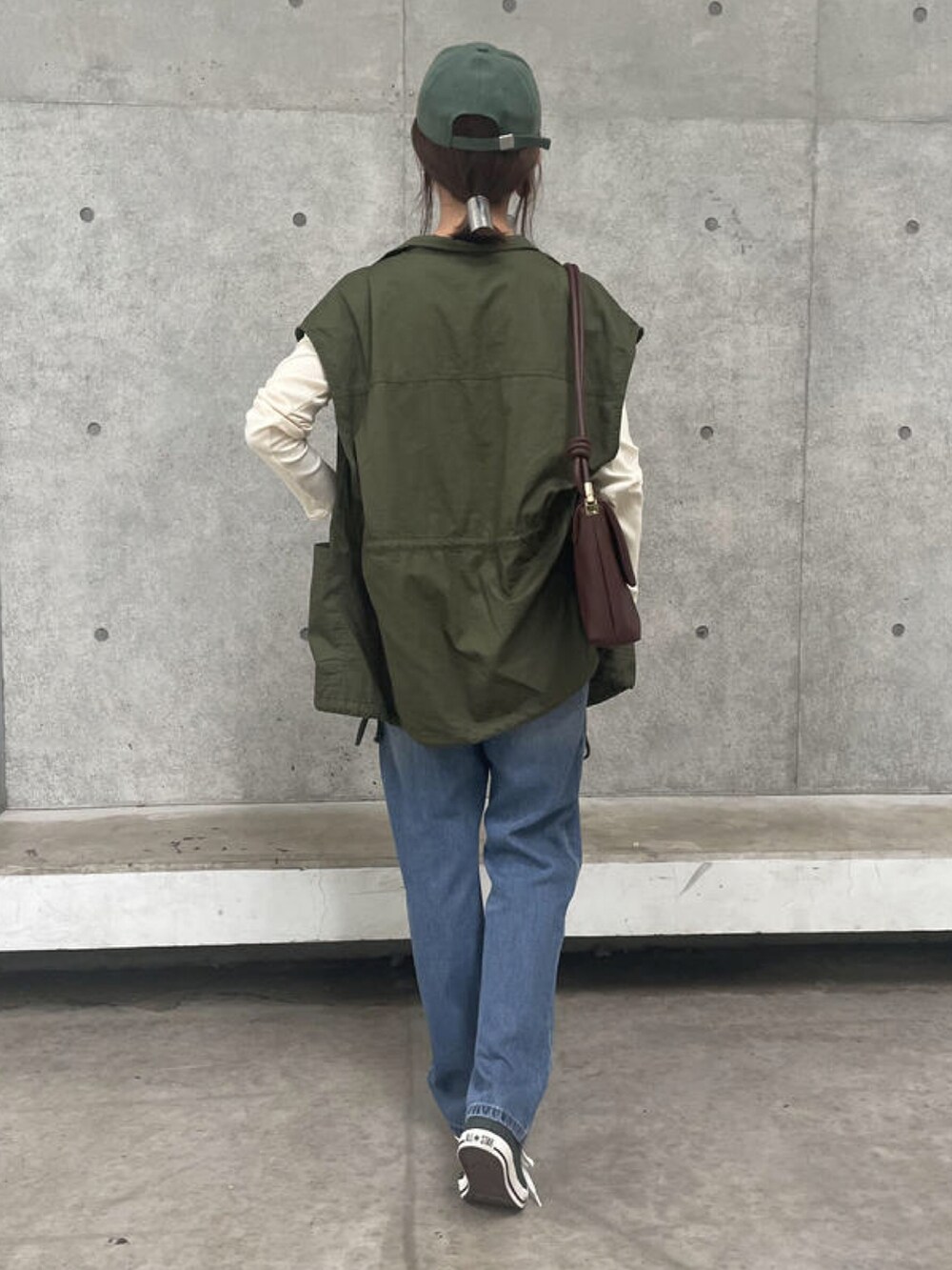 ホワイト系のTシャツ/カットソー、グリーン系のベスト、ブラウン系のショルダーバッグを着用したレディースの秋コーディネートの2枚目の写真