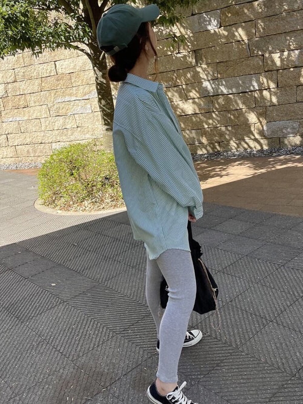 グリーン系のシャツ/ブラウス、ブラック系のスニーカー、ホワイト系のTシャツ/カットソーを着用したレディースの冬コーディネートの3枚目の写真