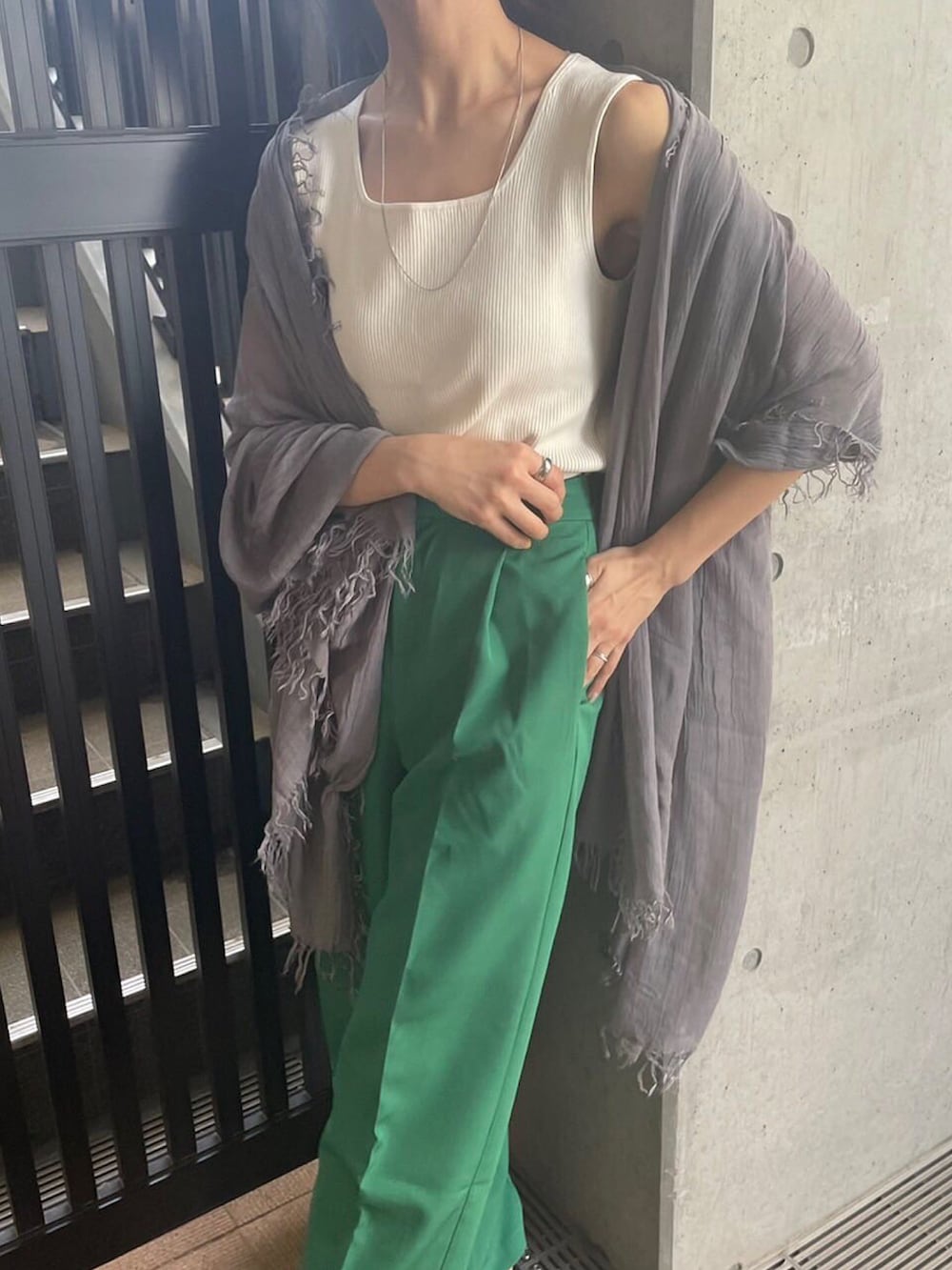 ホワイト系のタンクトップ、ブラック系のサンダル、グレー系のストール/ショールを着用したレディースの春コーディネートの4枚目の写真