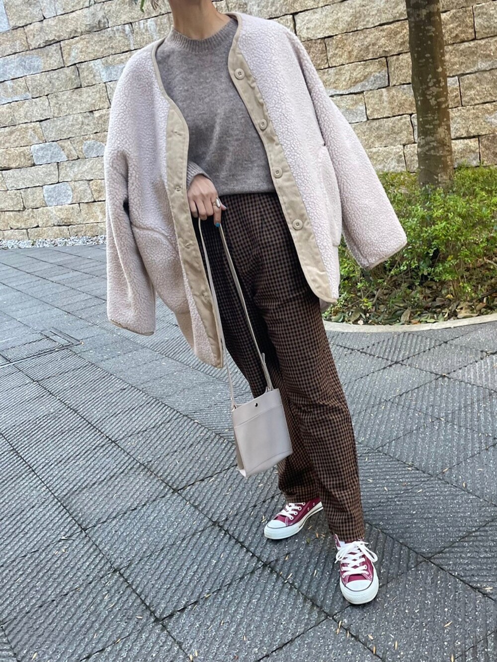 ホワイト系のニット/セーター、ブラウン系のその他パンツ、レッド系のスニーカーを着用したレディースの冬コーディネートの5枚目の写真