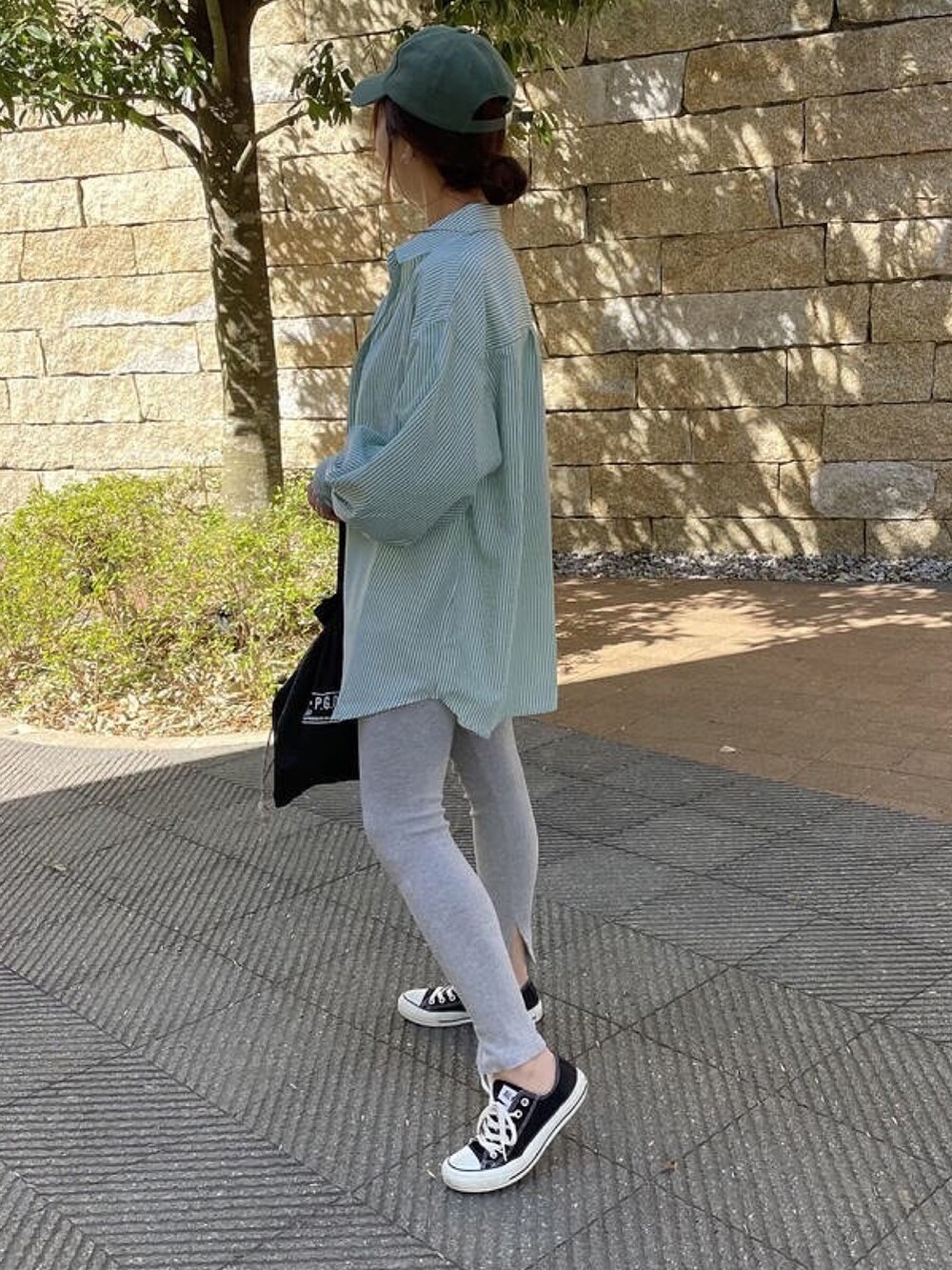 グリーン系のシャツ/ブラウス、ブラック系のスニーカー、ホワイト系のTシャツ/カットソーを着用したレディースの冬コーディネートの2枚目の写真
