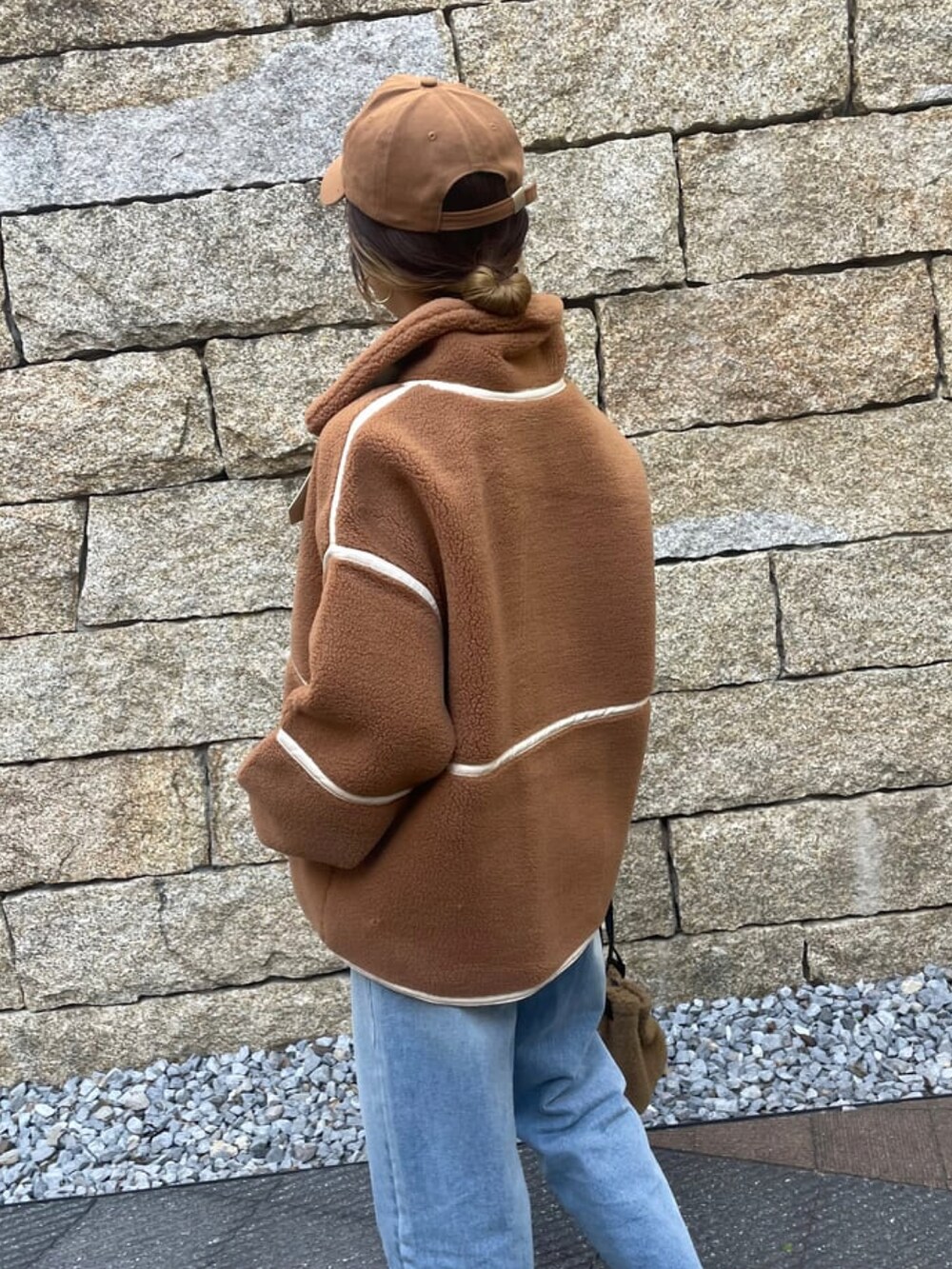 ブラウン系のその他アウター、ブルー系のデニムパンツ、その他のハンドバッグを着用したレディースの冬コーディネートの5枚目の写真