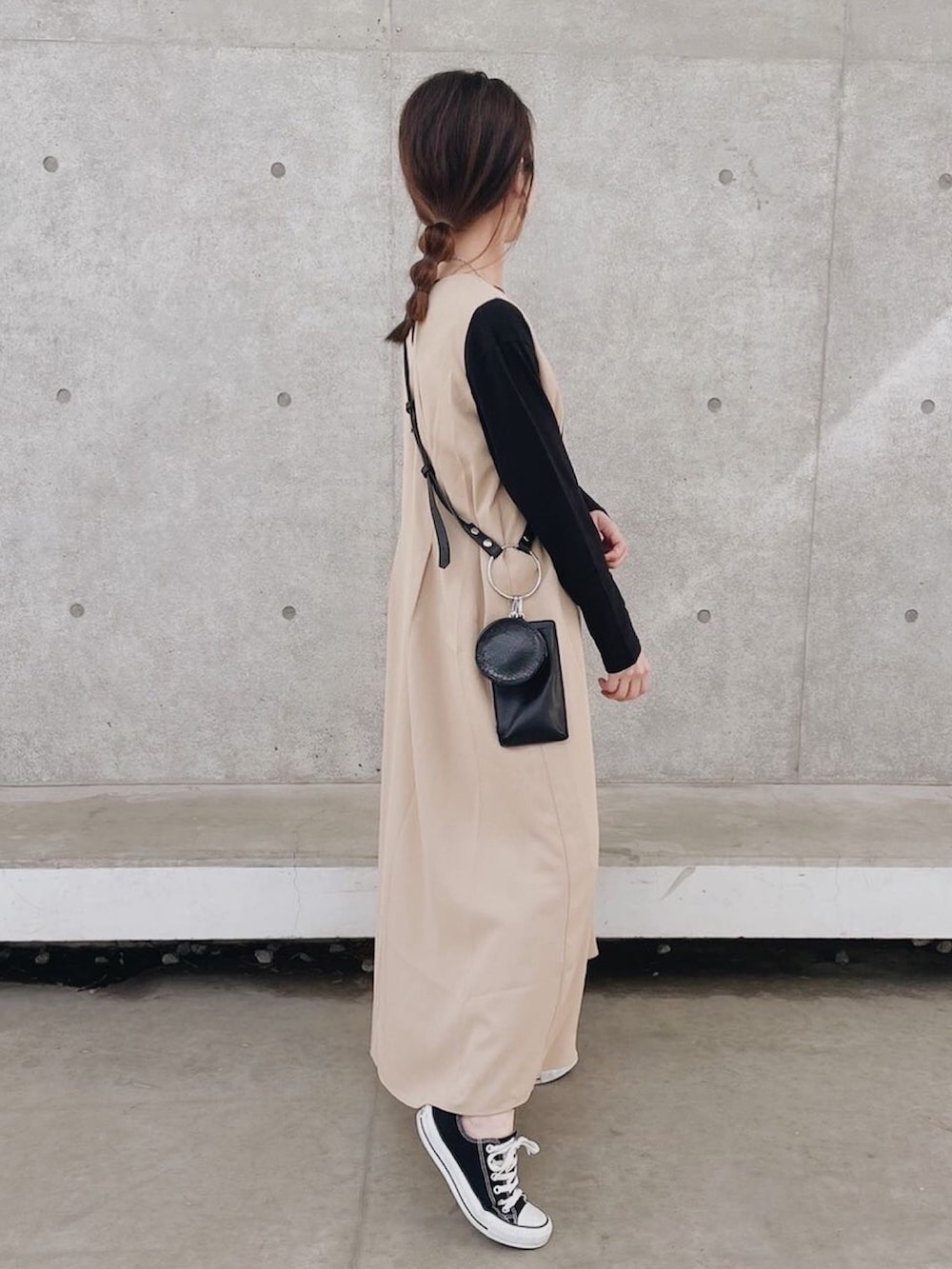 ベージュ系のワンピース、ブラック系のTシャツ/カットソー、ブラック系のスニーカーを着用したレディースの春コーディネートの3枚目の写真