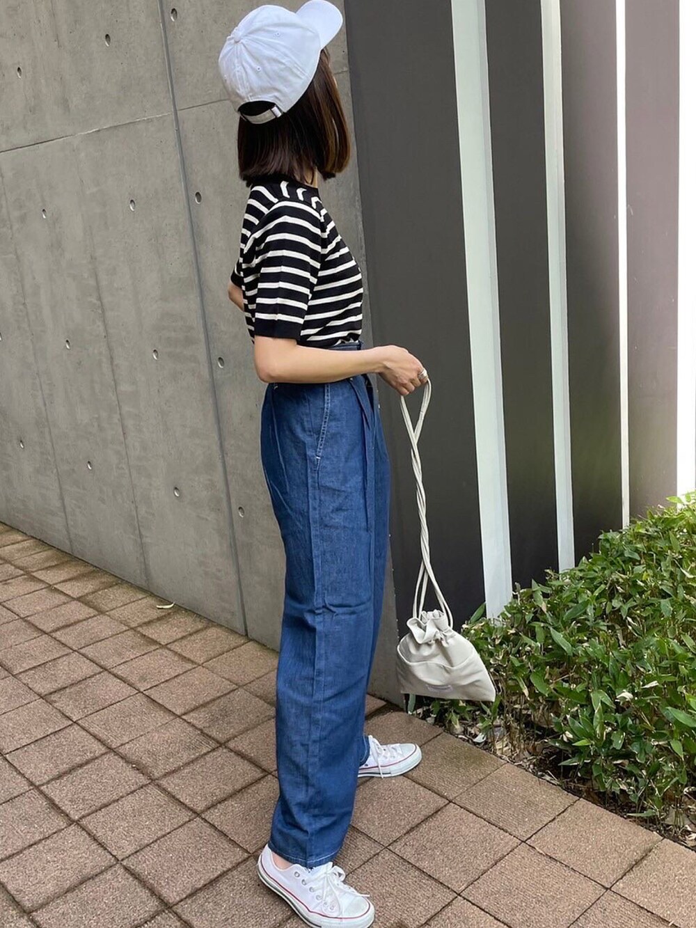 ブラック系のTシャツ/カットソー、ブルー系のデニムパンツ、ホワイト系のスニーカーを着用したレディースの春コーディネートの3枚目の写真