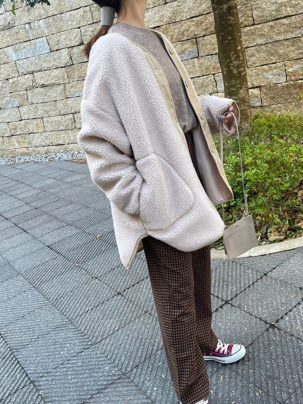 ホワイト系のニット/セーター、ブラウン系のその他パンツ、レッド系のスニーカーを着用したレディースの冬コーディネートの5枚目の写真