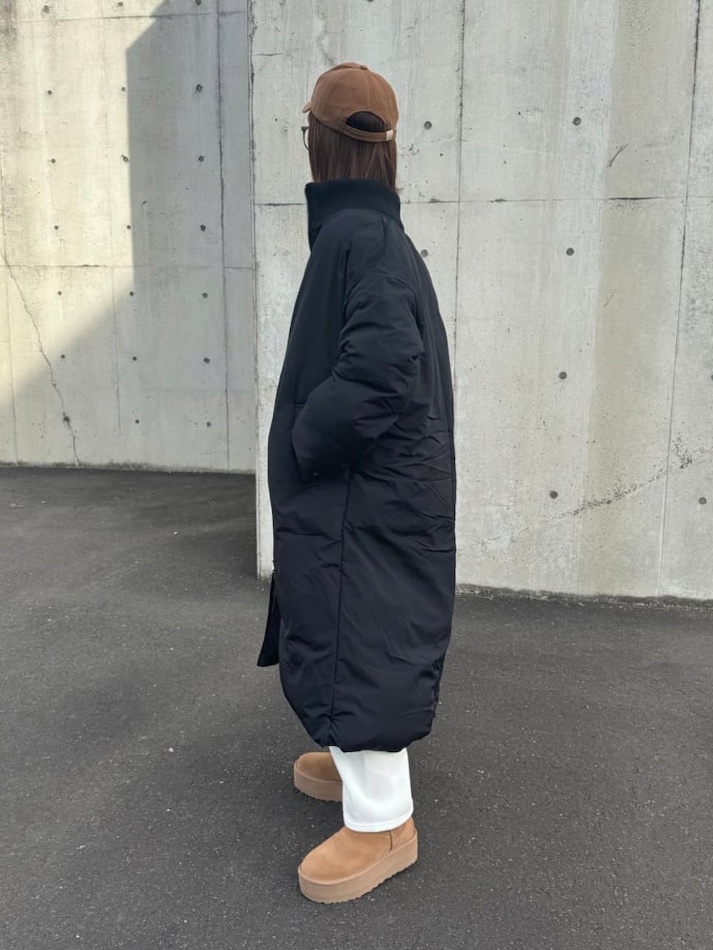 ブラック系のその他アウター、ブラック系のスウェット、ホワイト系のその他パンツを着用したレディースの冬コーディネートの3枚目の写真