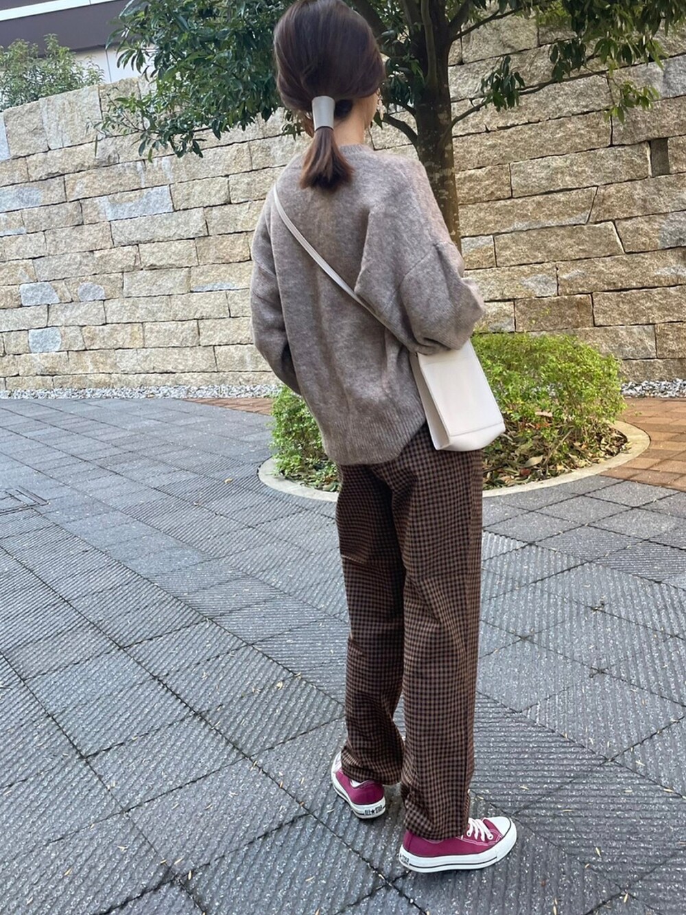 ホワイト系のニット/セーター、ブラウン系のその他パンツ、レッド系のスニーカーを着用したレディースの冬コーディネートの4枚目の写真