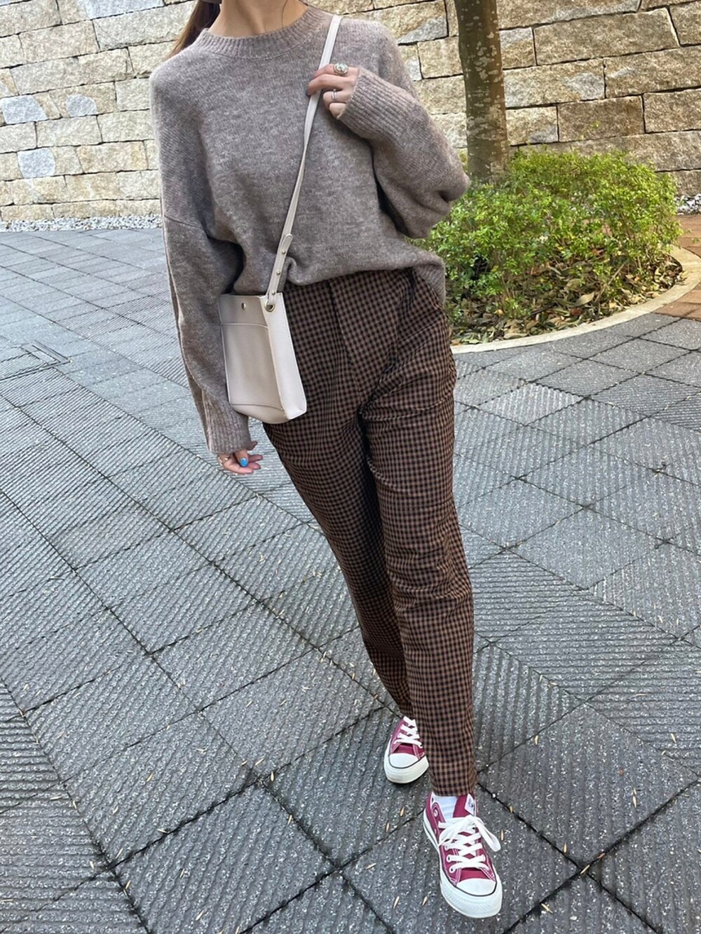 ホワイト系のニット/セーター、ブラウン系のその他パンツ、レッド系のスニーカーを着用したレディースの冬コーディネートの3枚目の写真