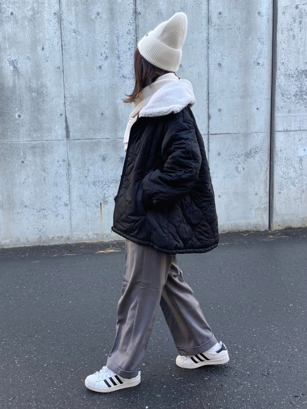 グレー系のスウェット、グレー系のパンツ、ホワイト系のスニーカーを着用したレディースの冬コーディネートの2枚目の写真