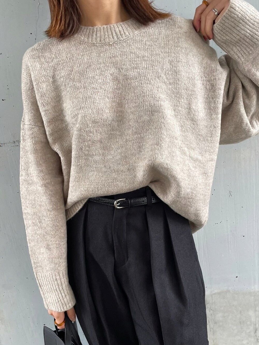 ベージュ系のニット/セーター、ブラック系のパンツ、ブラック系のバッグを着用したレディースの秋コーディネートの3枚目の写真