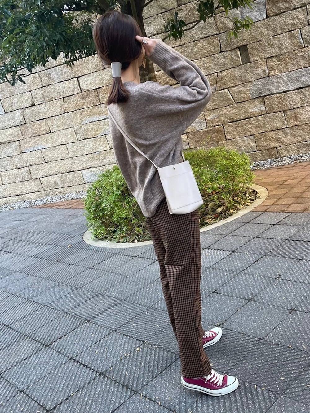 ホワイト系のニット/セーター、ブラウン系のその他パンツ、レッド系のスニーカーを着用したレディースの冬コーディネートの2枚目の写真