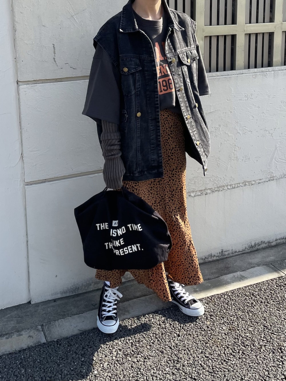 ブラック系のトップス、ブラック系のデニムジャケット、ブラウン系のスカートを着用したレディースの冬コーディネートの4枚目の写真